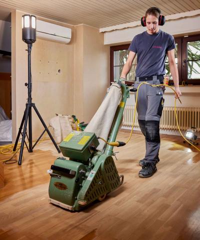 Apprentis en train de poncer un parquet